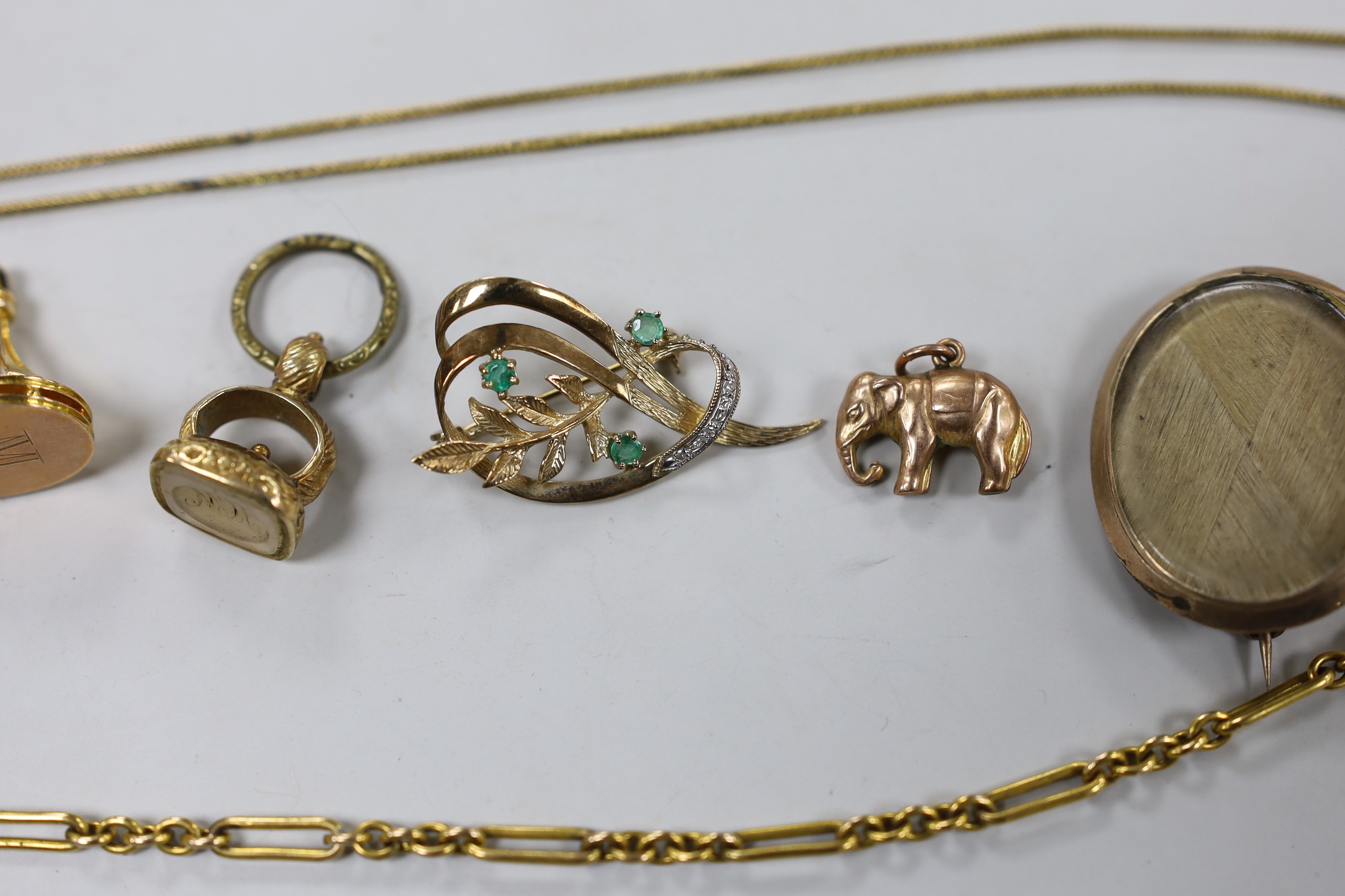 A small collection of Victorian and later jewellery, including two fob seals, two yellow metal charms, a 9ct pendant on a yellow metal chain, mourning pendant, gilt metal albert and a gem set yellow metal foliate brooch.
